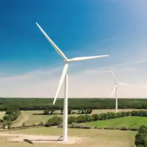 Large wind turbines in a green landscape for renewable energy and sustainability.