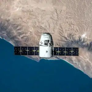 Satellite space station orbiting over desert and ocean landscape.